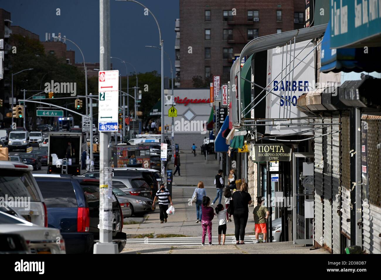 I clienti si fanno strada lungo la 108th Street nel quartiere di Forest Hills, designata "zona rossa", Queens, NY, 7 ottobre 2020. Gov. Andrew Cuomo ha adottato un sistema di zone colorate a tre livelli (giallo, arancione e rosso), piuttosto che utilizzare i codici di avviamento postale, per identificare i quartieri che stanno vedendo un picco significativo nelle infezioni da Coronavirus, e imporre diverse restrizioni in base al colore della zona, il rosso essendo il più alto. Le restrizioni della zona rossa includono un massimo di 10 persone all'interno delle case di culto, sono vietate le riunioni di gruppo, solo le imprese essenziali possono rimanere aperte, le scuole in re Foto Stock