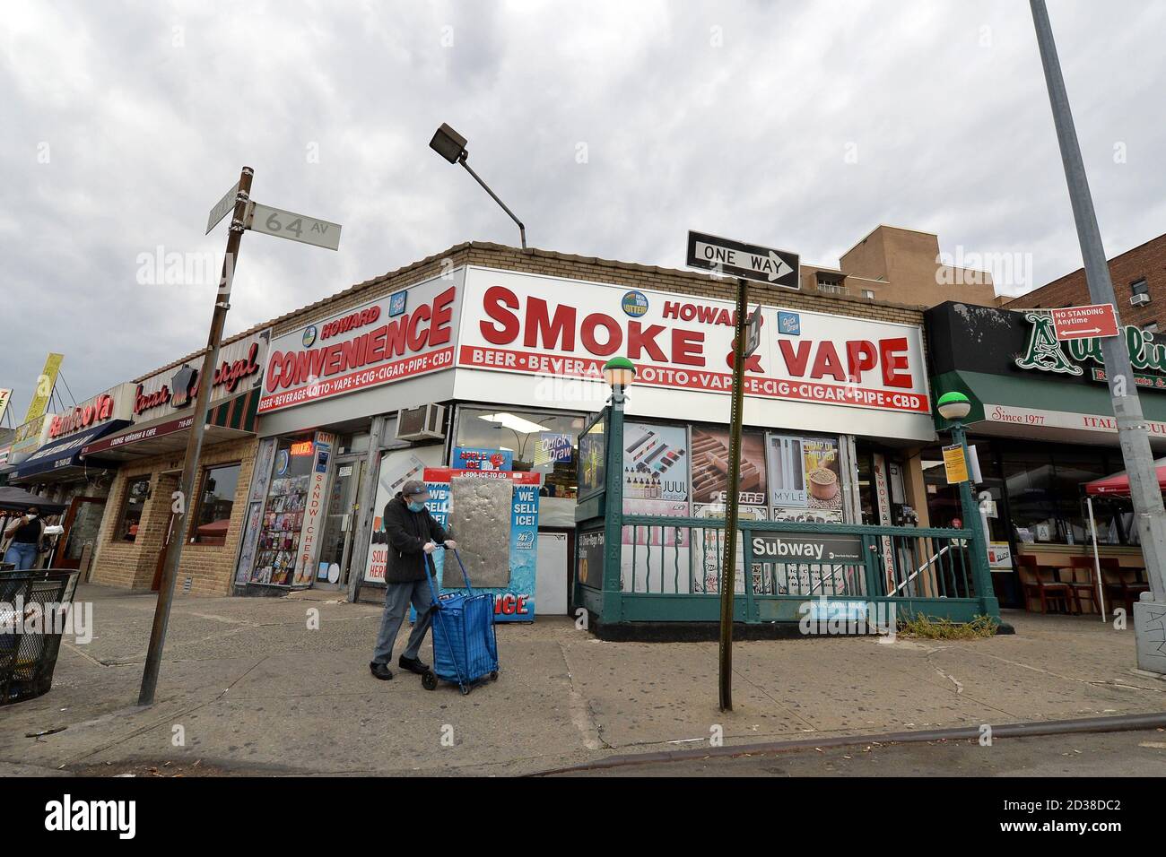 Una donna anziana spinge un carrello mentre si prepara ad attraversare la 64th Avenue sul lato della "zona rossa" di Queens Blvd, nel quartiere Queens di New York, NY, 7 ottobre 2020. Gov. Andrew Cuomo ha adottato un sistema di zone colorate a tre livelli (giallo, arancione e rosso), piuttosto che utilizzare i codici di avviamento postale, per identificare i quartieri che stanno vedendo un picco significativo nelle infezioni da Coronavirus, e imporre diverse restrizioni in base al colore della zona, il rosso essendo il più alto. Le restrizioni della zona rossa includono un massimo di 10 persone all'interno delle case di culto, sono vietate le riunioni di gruppo, solo essenziale b Foto Stock