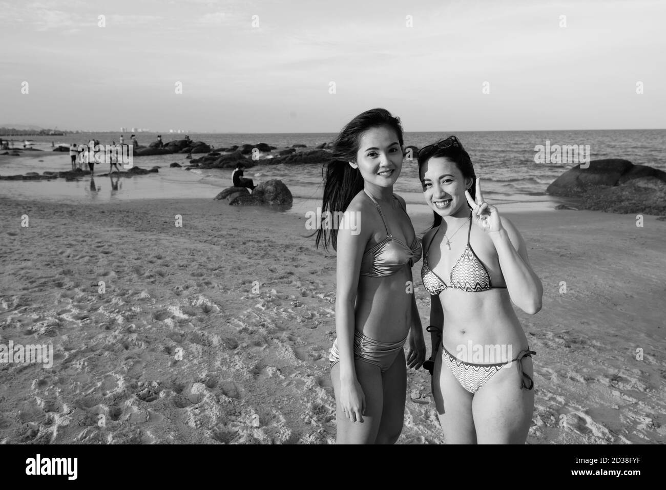 Due giovani felici belle donne asiatiche sorridenti insieme al spiaggia Foto Stock