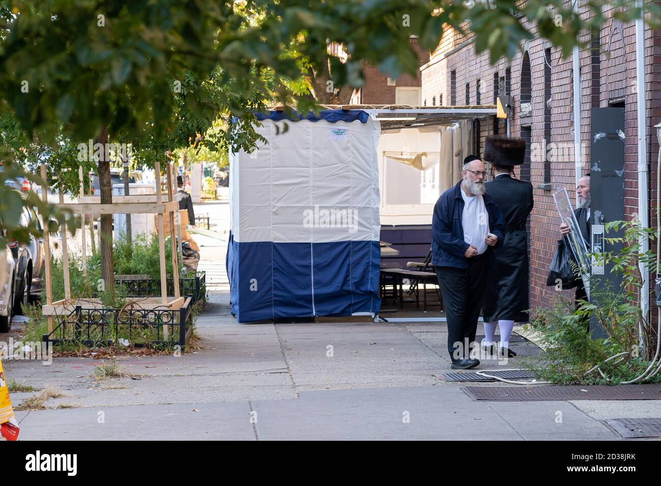 NEW YORK, NY - 07 OTTOBRE 2020: Uomini ebrei ortodossi che non indossano maschere visti vicino Sukkah nel quartiere di Borough Park a Brooklyn. Foto Stock