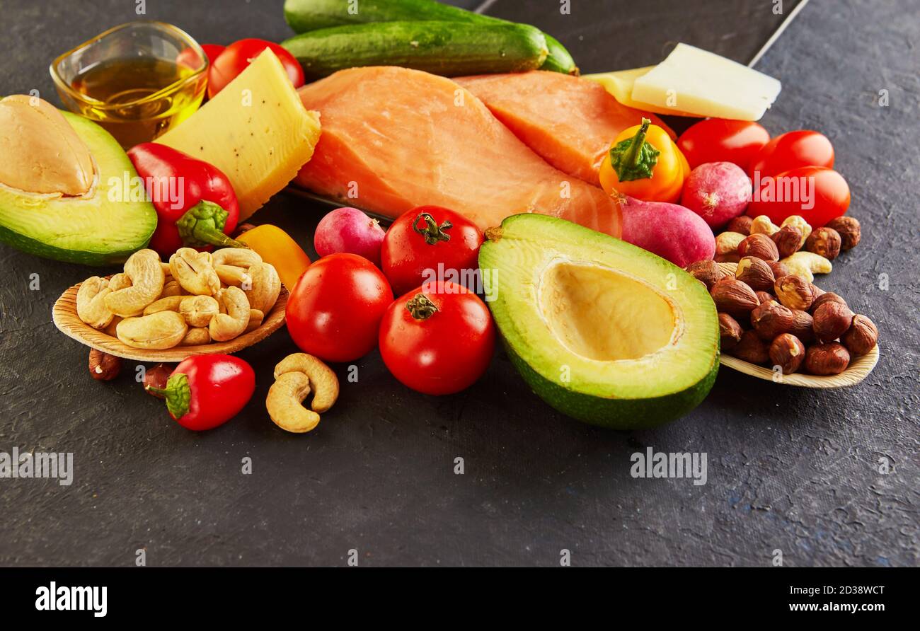 Concetto di dieta chetogena. Set di alimenti con dieta a basso contenuto di carboidrati. Verdure verdi, noci, filetti di pesce, pomodori ciliegini. Concetto di cibo sano. Foto Stock