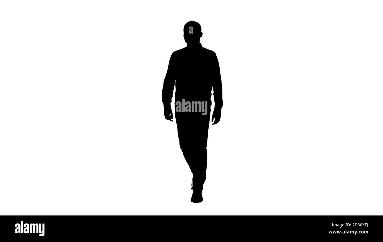 Silhouette giovane uomo che cammina di buon umore. Foto Stock