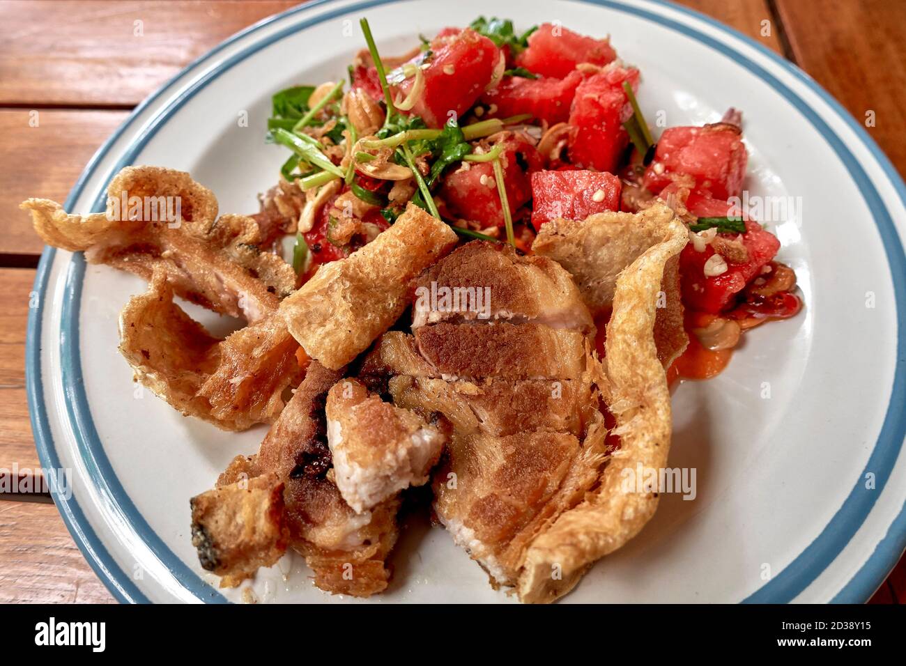 Pancia di maiale croccante e melone d'acqua piccante compongono questo piatto tradizionale tailandese insolito combinazione di cibo. Foto Stock