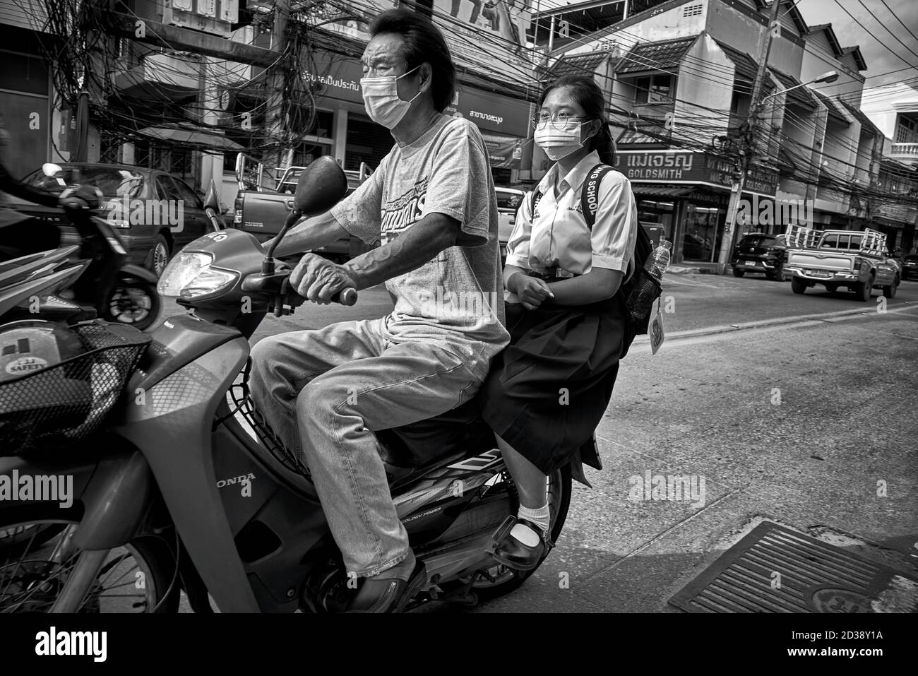 Thailandia moto persone. La scuola della Thailandia corre con il padre che trasporta la figlia sulla moto. Sud-est asiatico. Fotografia in bianco e nero Foto Stock