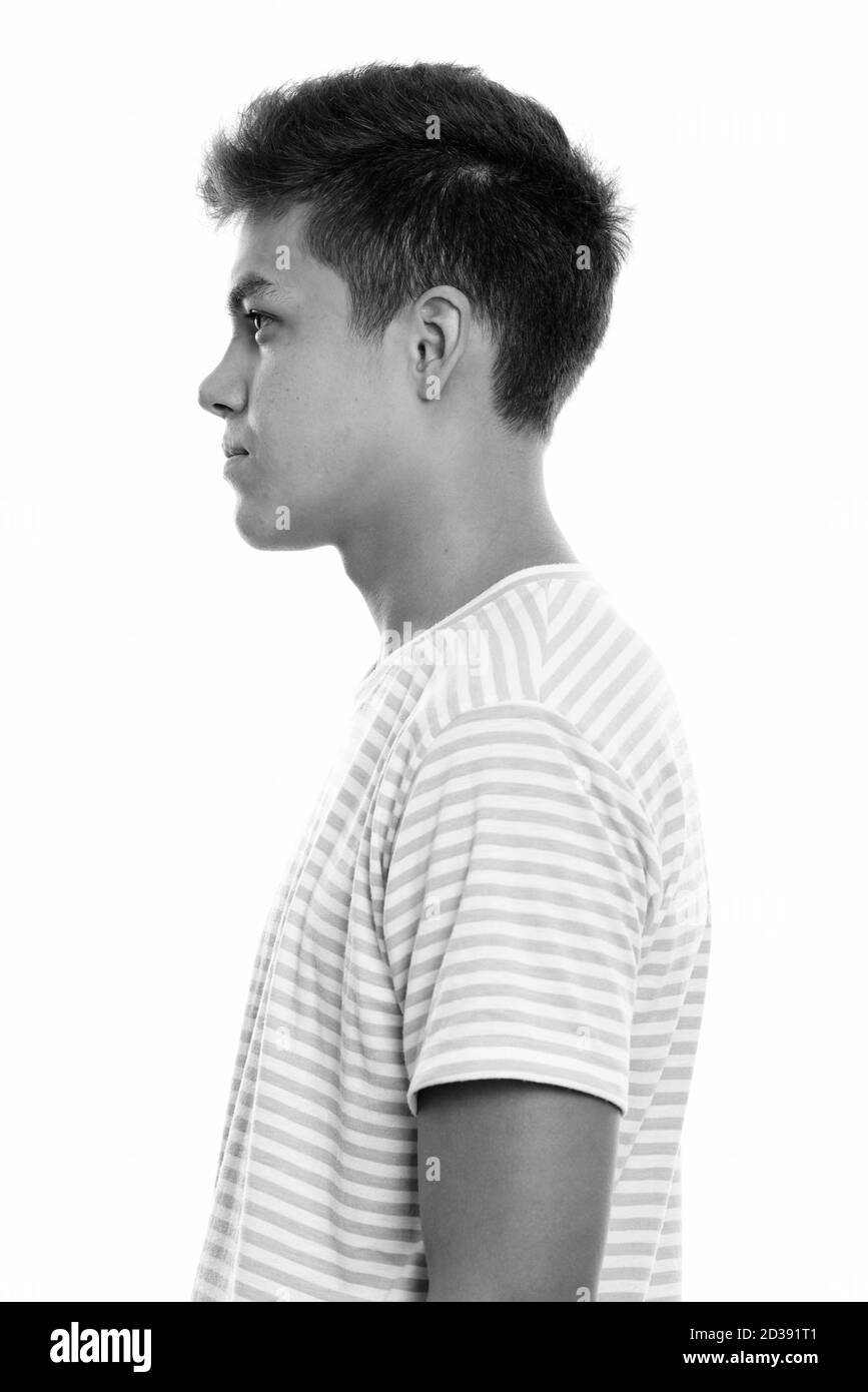 Vista di profilo del giovane uomo bello contro uno sfondo bianco Foto Stock