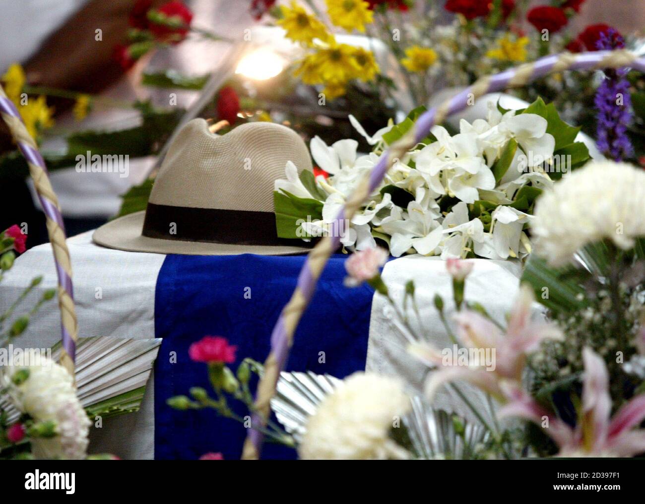 Il cappello di marchio del musicista cubano Compay Segundo giace tra fiori  su Segundo, con la bandiera cubana coperta, nel casket di un salone  funerario a l'Avana, 14 luglio 2003. Compay Segundo