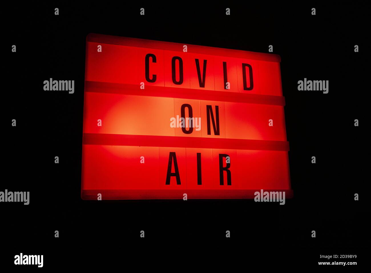 Un segno rosso luminoso con la parola COVID attivata aria Foto Stock