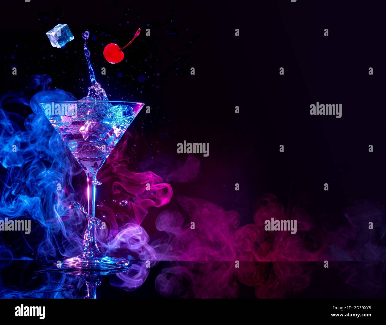 cocktail martini con spruzzi su sfondo fumoso blu e viola Foto Stock