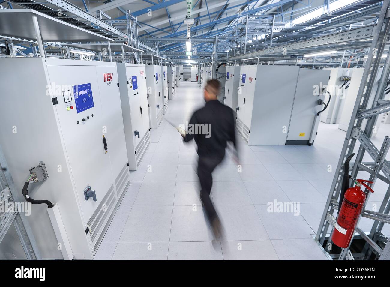 25 settembre 2020, Sassonia-Anhalt, Sandersdorf-Brehna: Un dipendente lavora nel centro di fornitura di energia del nuovo centro di test e sviluppo per le batterie dei veicoli. Nei circa 12,000 metri quadrati e quindi il centro più grande del mondo, vengono testate batterie ad alte prestazioni per auto elettriche. Un intero arsenale di strumenti di tortura attende le batterie. Tutti i dispositivi di accumulo di energia vengono spinti fino ai limiti, dallo schiacciamento, al immersione, al riscaldamento, al congelamento, allo scuotimento, al trattamento con polvere e sale, fino al corto circuito controllato. In Sassonia-Anhalt, FEV ha avuto un centro di test per la combustione convenzionale Foto Stock