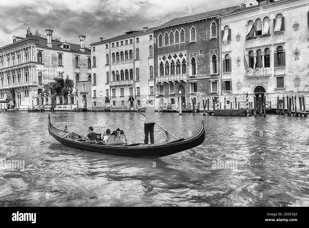 Persone non identificate su un tradizionale Gondola con architettura paesaggistica lungo il Canal Grande nel sestiere di Cannaregio a Venezia, Italia Foto Stock