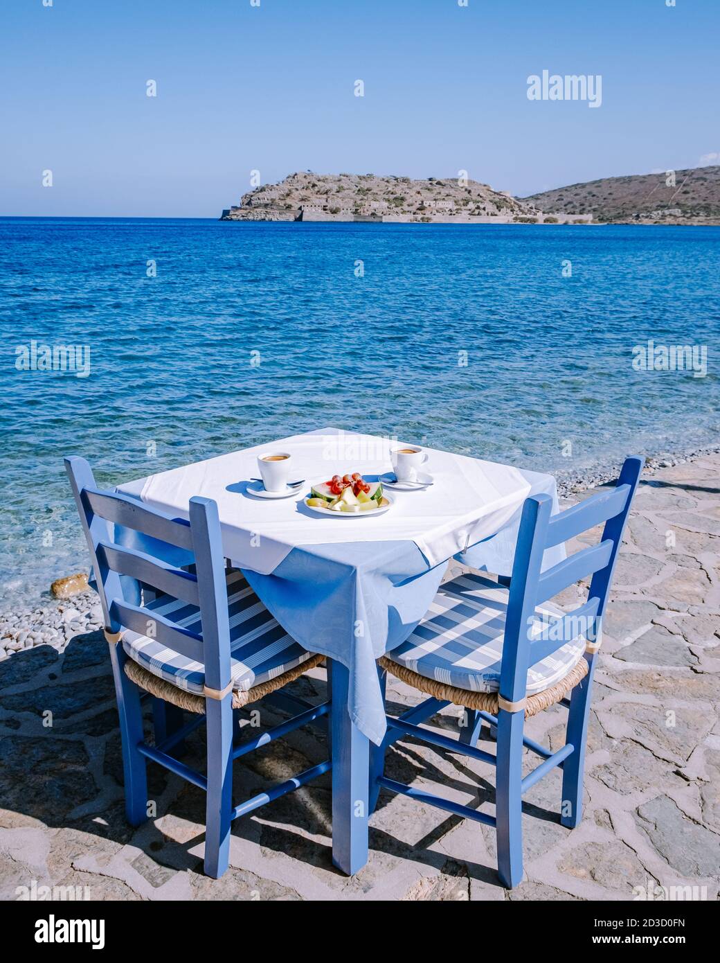 Plaka Lassithi con è tradizionale tavolo blu e sedie e. La spiaggia di Creta Grecia Foto Stock