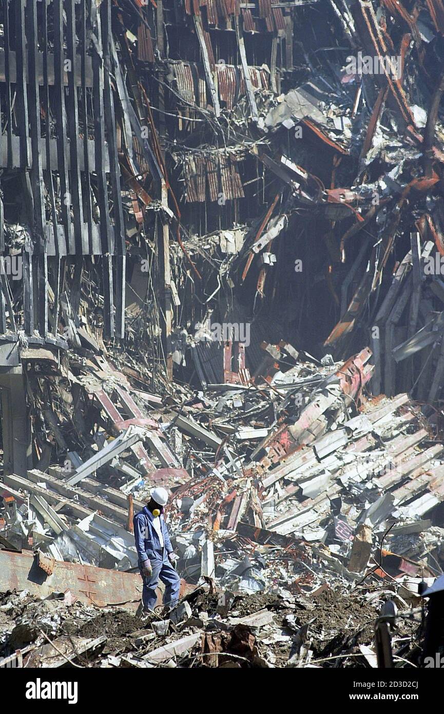 Un lavoratore solo cerca attraverso i detriti nel sito del disastro del World Trade Center 2 ottobre 2001, a New York. Gli sforzi di ripulimento continuano a seguito dell'attacco di settembre 11 alle due torri che le hanno provocate al collasso. REUTERS/Pool/Tony Gutierrez GAC Foto Stock
