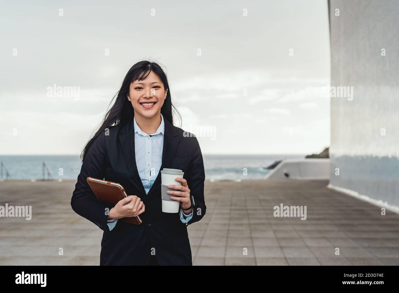 Donna asiatica d'affari che tiene tablet intelligente e bere take away Caffè fuori ufficio - imprenditore professionale concetto di lavoro Foto Stock