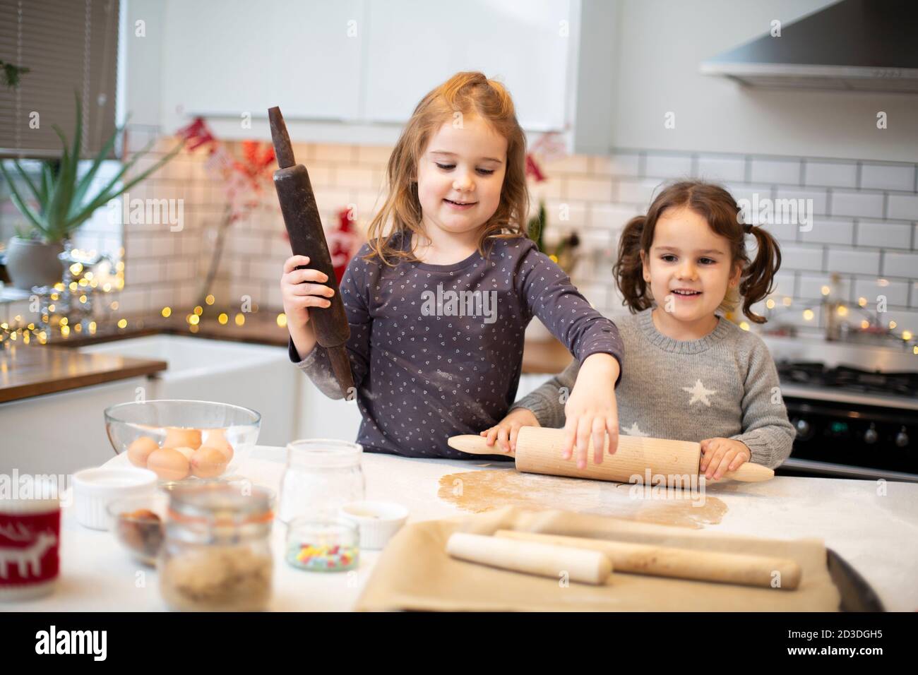 Due ragazze in piedi in cucina, cucinando i biscotti di Natale. Foto Stock