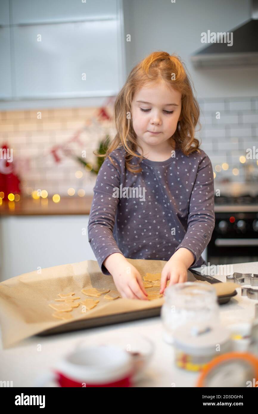 Ragazza in piedi in cucina, cottura biscotti di Natale. Foto Stock