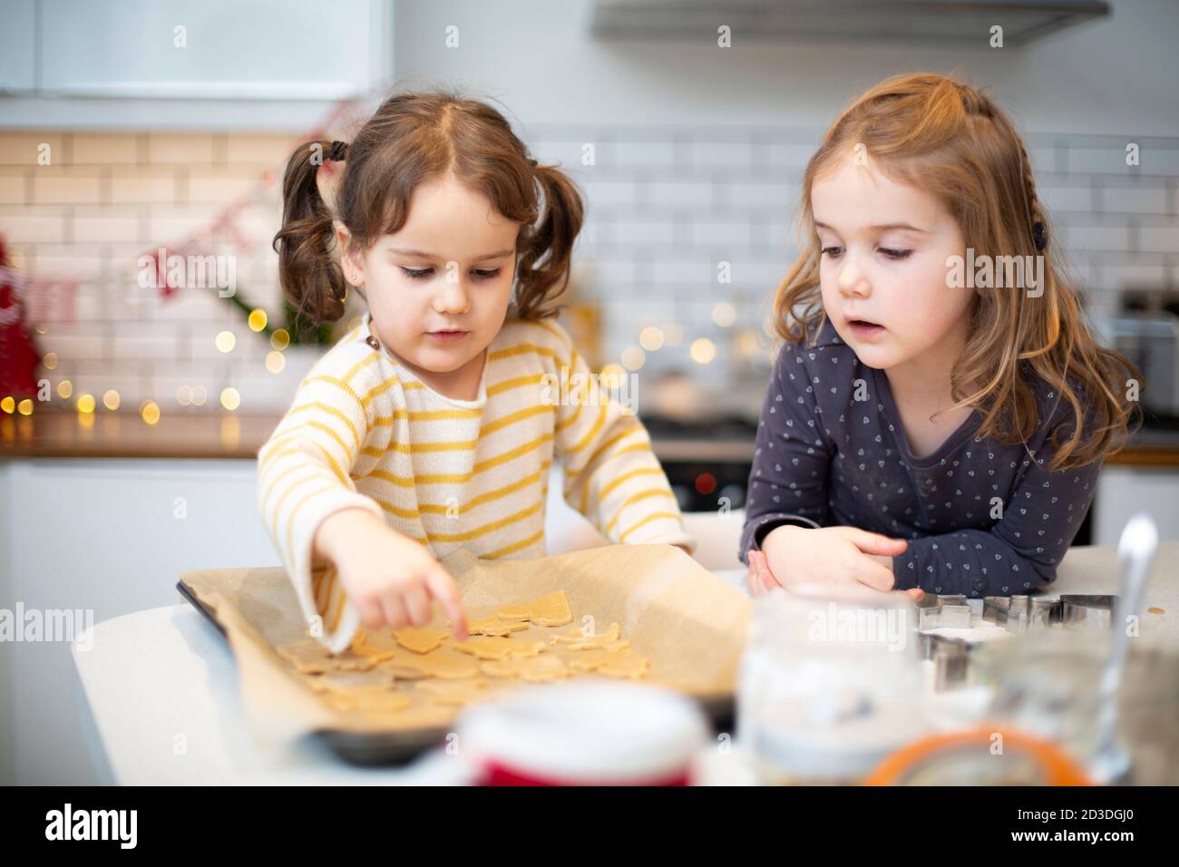 Due ragazze in piedi in cucina, cucinando i biscotti di Natale. Foto Stock