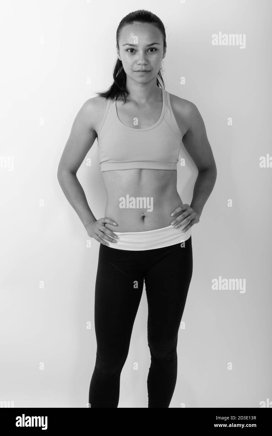 Studio di giovane donna asiatica in piedi pronti per la palestra su sfondo bianco Foto Stock