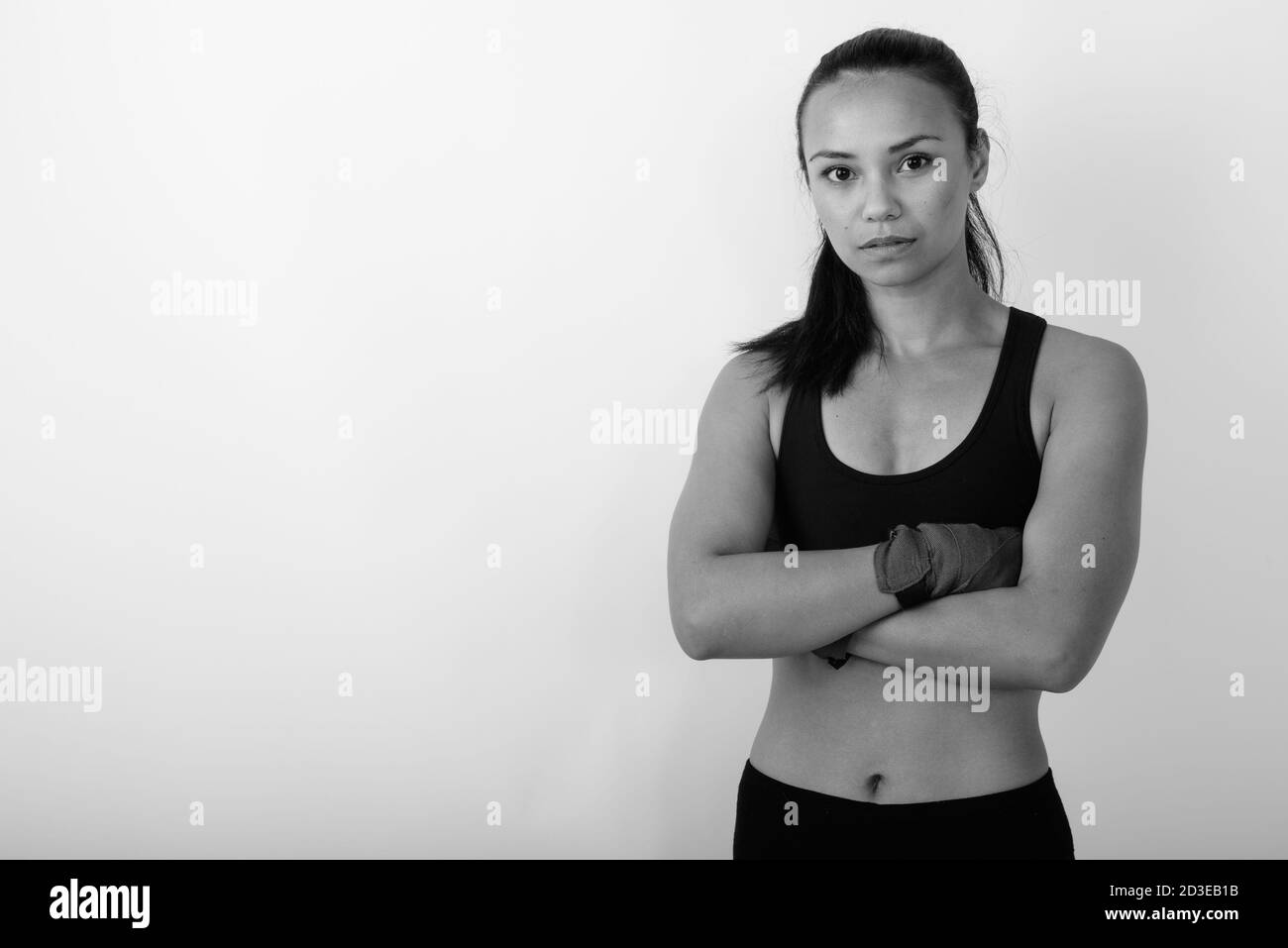 Studio girato di giovane donna asiatica combattente con le braccia incrociate su sfondo bianco Foto Stock