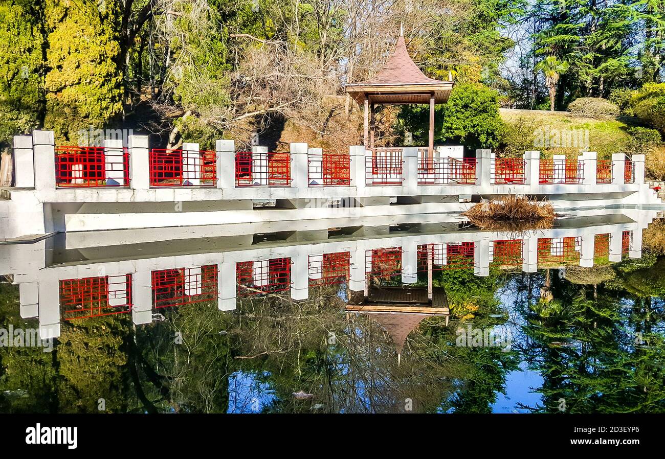 Gazebo in legno e laghetto incorniciato da pietra bianca nell'arboreto di Sochi. Russia Foto Stock