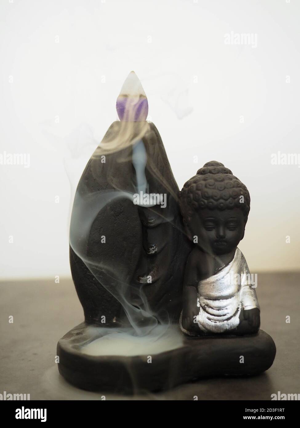 buddha in ceramica nera con incenso Foto Stock