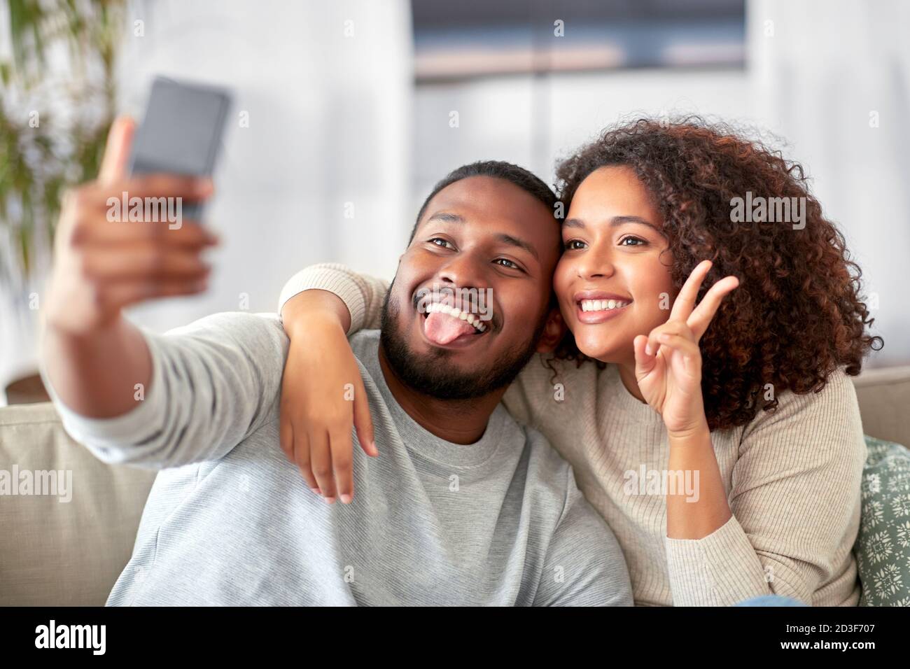 Coppia felice con lo smartphone tenendo selfie a casa Foto Stock