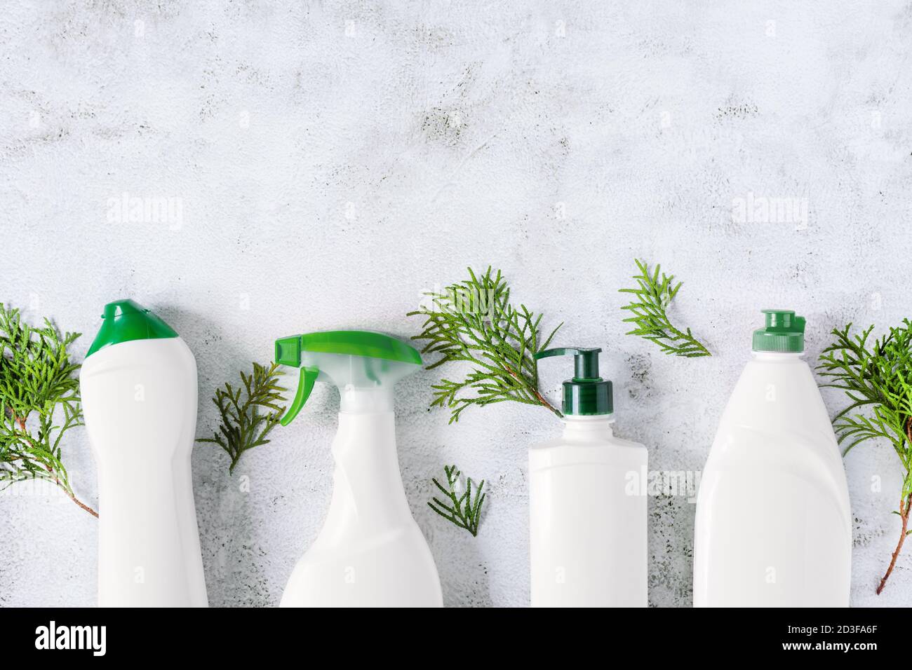 Set di diversi flaconi di detergente bio-organico per la pulizia della casa vista dall'alto su fondo grigio in cemento. Bottiglie per etichette vuote per la progettazione. Foto Stock