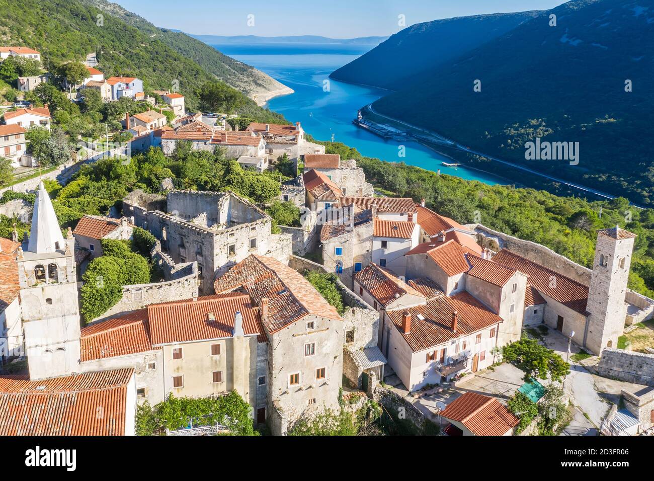 Veduta aerea di Plomin e della Chiesa Parrocchiale della Beata Vergine Maria con un campanile, sullo sfondo canale Plomin, Istria, Croazia Foto Stock