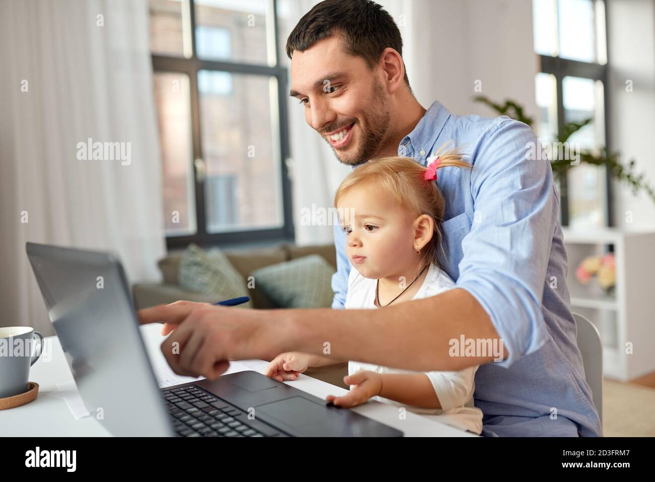 padre che lavora con la figlia del bambino nell'ufficio domestico Foto Stock