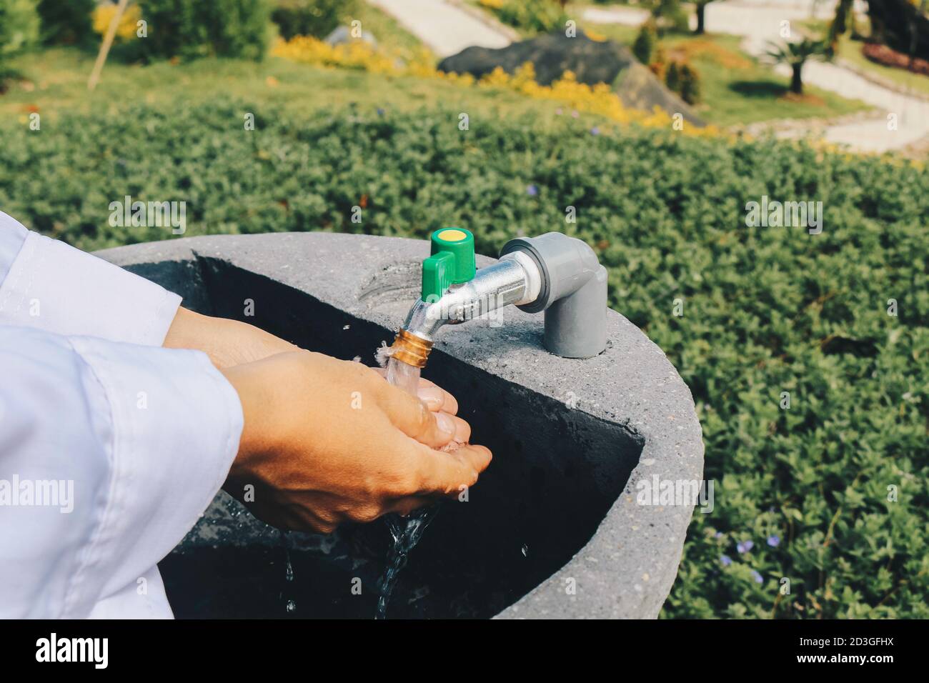 Donne che lavano le mani con sfondo naturale sotto la luce del sole. Concetto di igiene dettaglio delle mani. Foto Stock