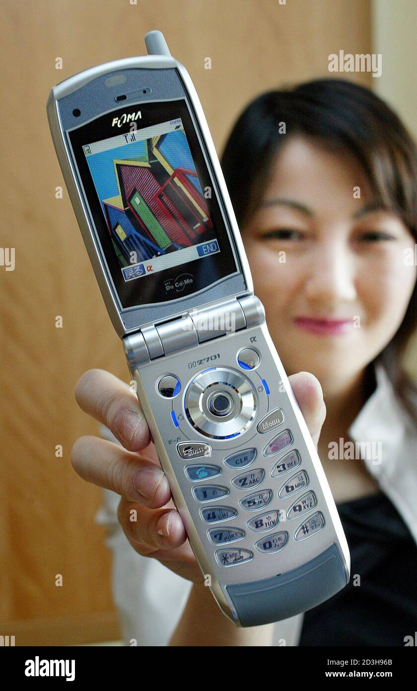 Un dipendente dell'operatore di telefonia mobile giapponese NTT DoCoMo  mostra il suo nuovo telefono cellulare FOMA N2701, il primo microtelefono a  doppia rete a Tokyo il 30 maggio 2003. Il telefono cellulare