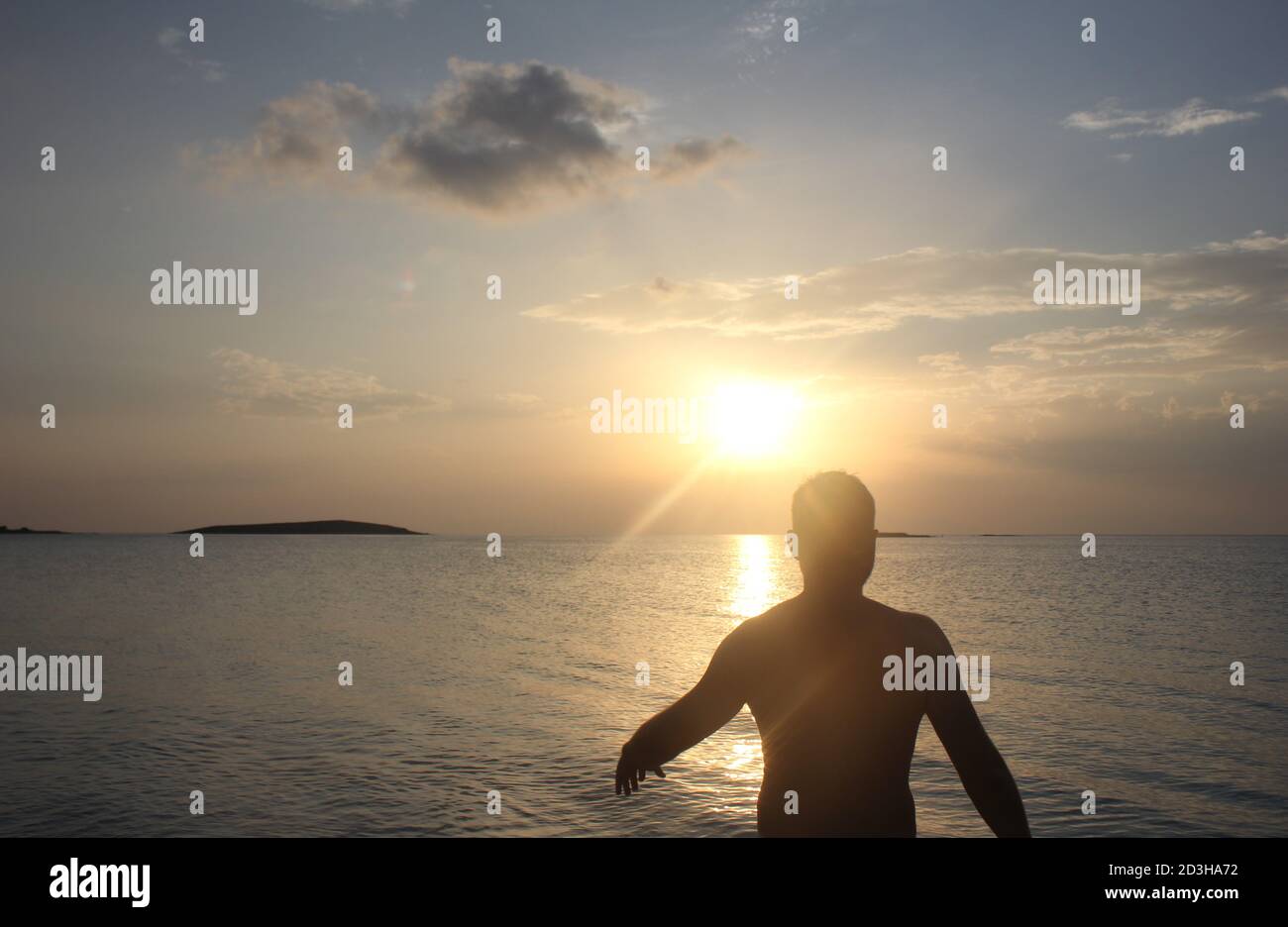 Un uomo gioca al Tramonto a Panagia Beach nell'isola di Elafonisos, nella parte meridionale del Peloponneso, in Grecia Foto Stock