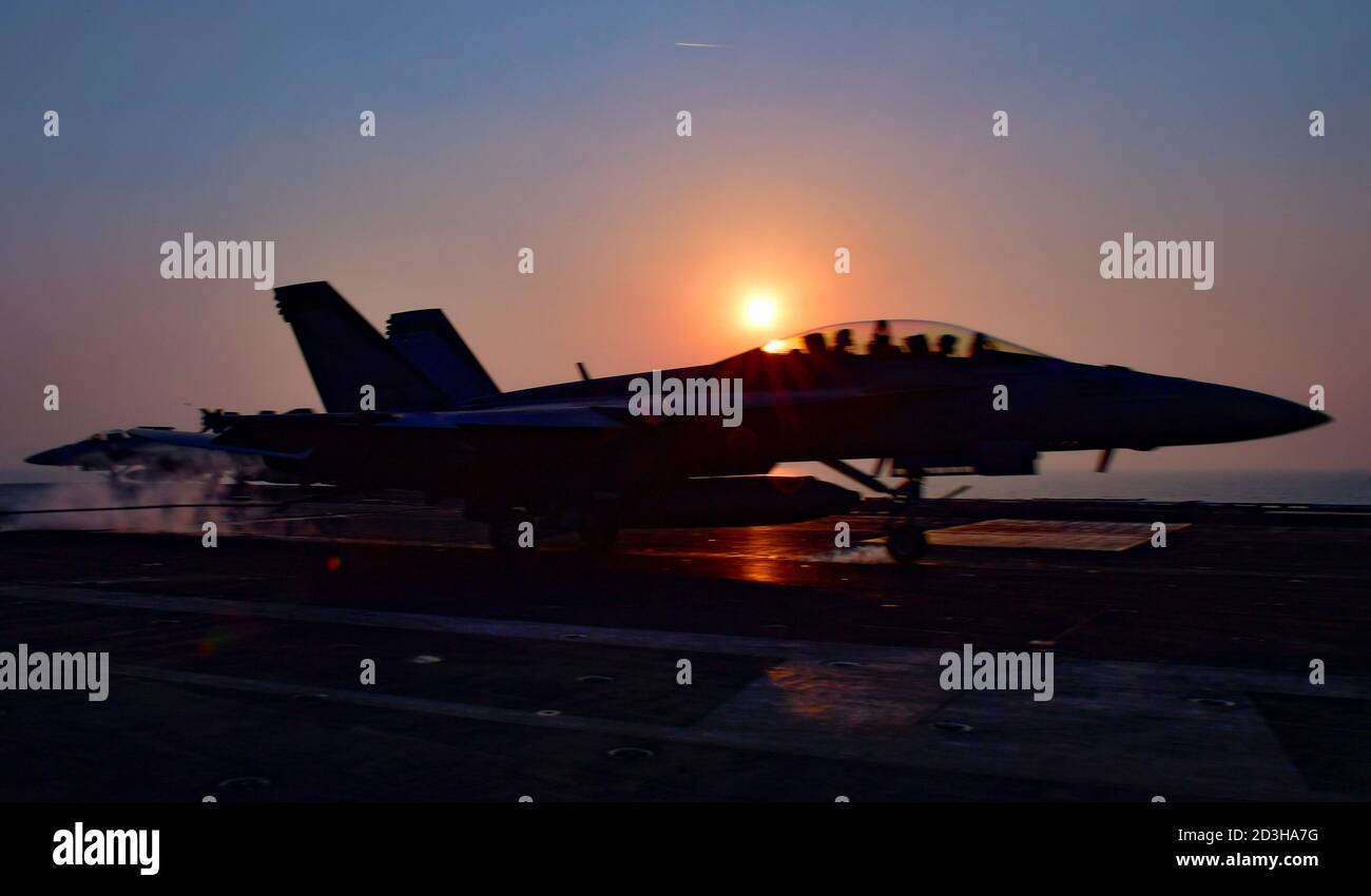 Un aereo da combattimento US Navy F/A-18F Super Hornet con i Mighty Shrikes of Strike Fighter Squadron 94 atterra al tramonto sul ponte di volo della portaerei di classe Nimitz USS Nimitz 6 ottobre 2020 nel Golfo Persico. Foto Stock