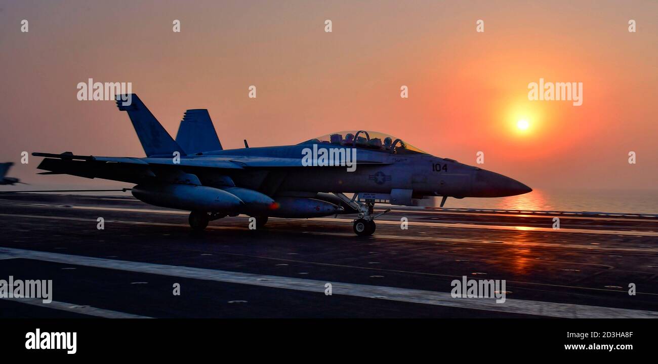 Un aereo da combattimento US Navy F/A-18F Super Hornet con i Fighting Redcks of Strike Fighter Squadron 22 atterra al tramonto sul ponte di volo della portaerei di classe Nimitz USS Nimitz 6 ottobre 2020 nel Golfo Persico. Foto Stock