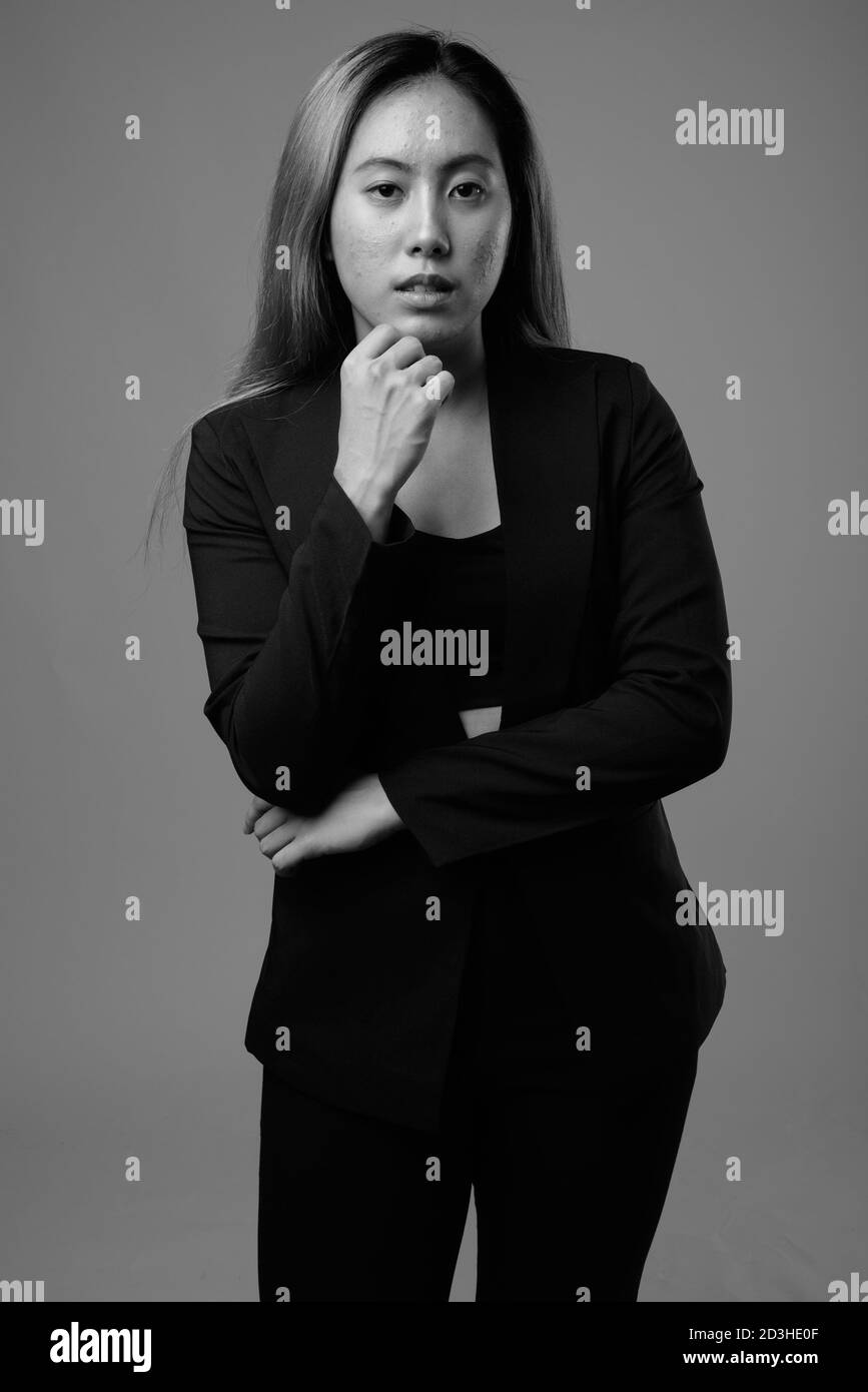 Ritratto di giovane donna d'affari asiatica su sfondo grigio Foto Stock