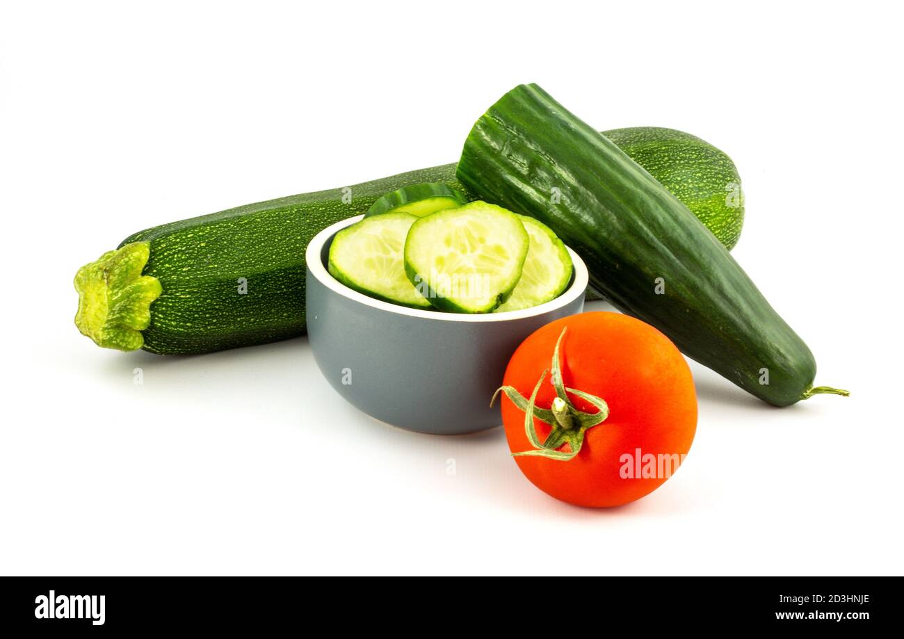 Cetriolo verde a fette, pomodoro rosso e zucchina verde isolata su sfondo bianco. Cibo sano. Foto Stock