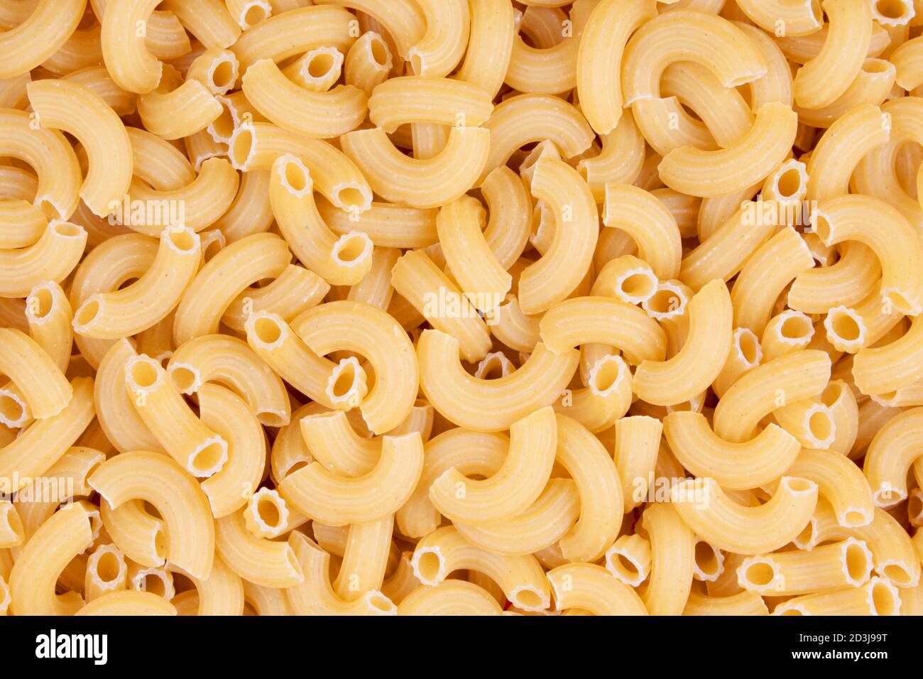 Uno sfondo di un primo piano di una piastra di maccheroni grezzi a gomito Foto Stock
