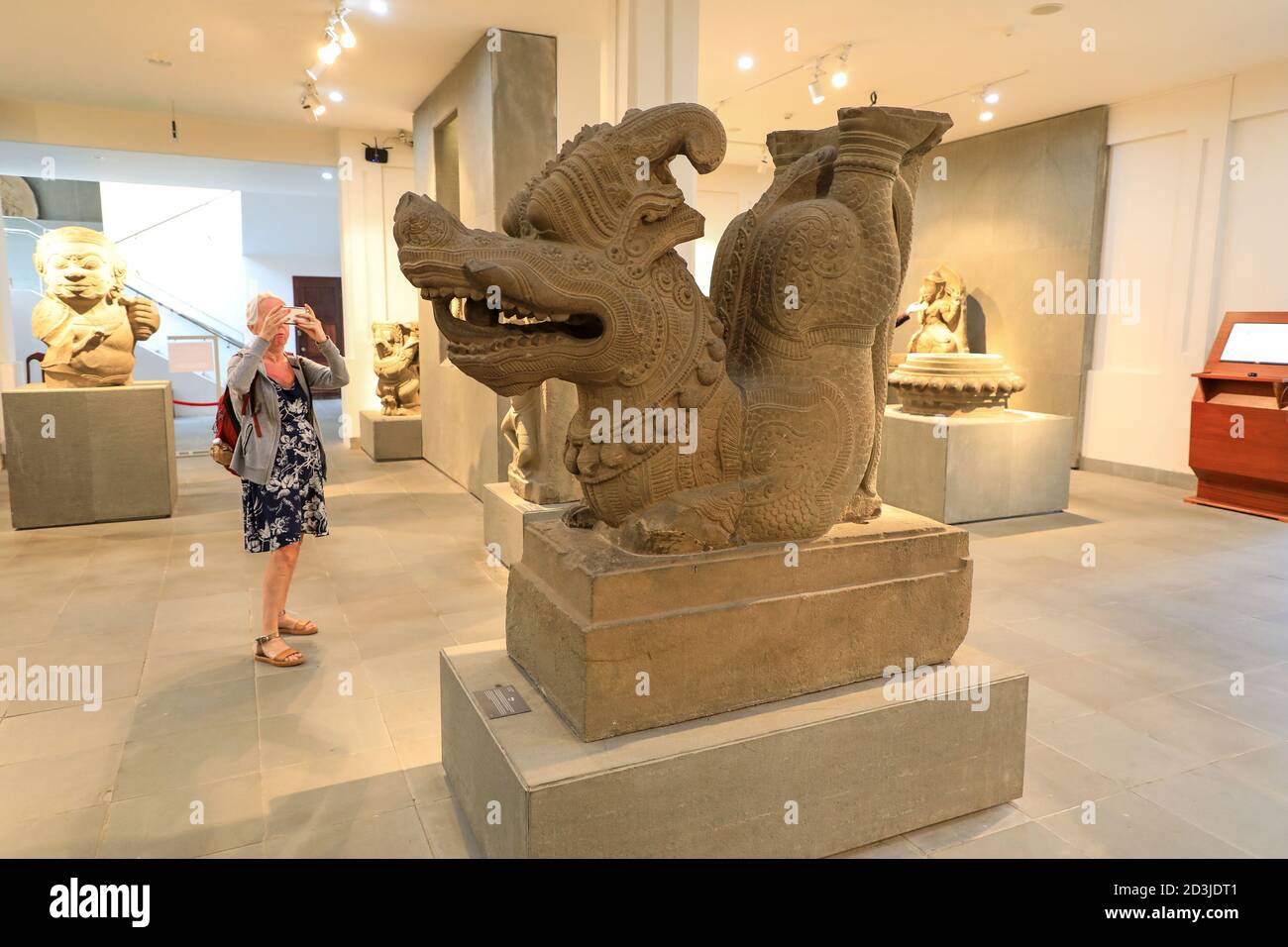 Una donna che scattava una foto di una scultura di un Rong o di un drago al Museo della scultura di Cham, Danang, Vietnam, Asia Foto Stock