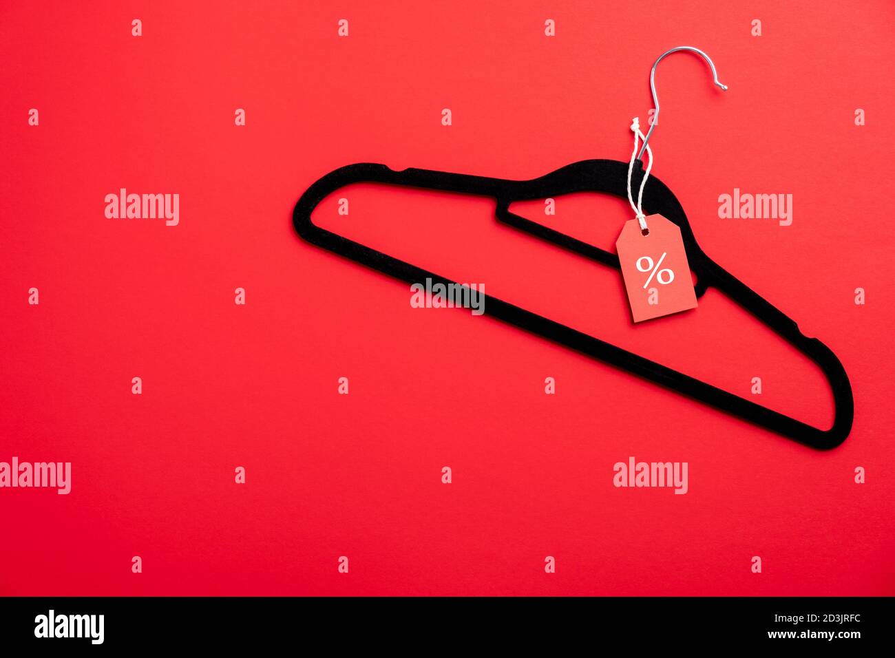 Vendita del Black Friday. Appendiabiti con etichetta di vendita su sfondo rosso. Disposizione piatta, vista dall'alto. Foto Stock