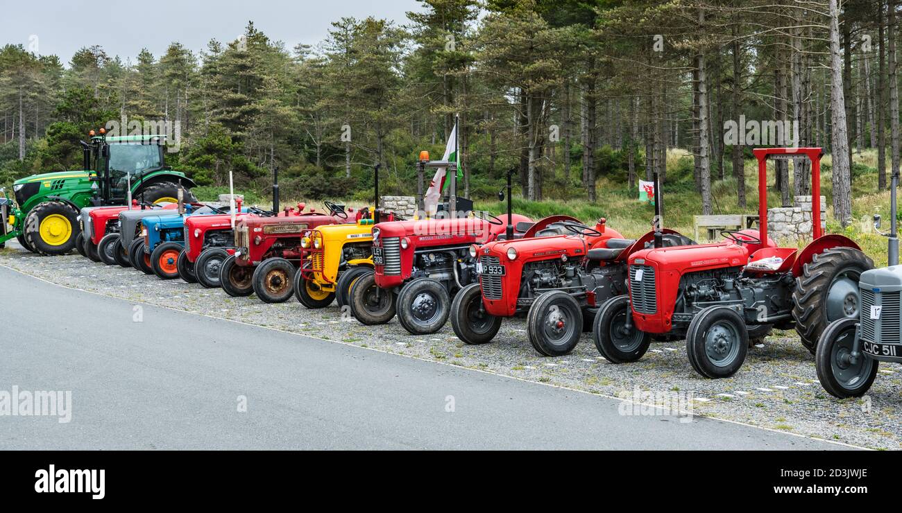 Una linea di trattori, nuovi e vecchi, a Newborough Beach Car Park, Anglesey, Galles Foto Stock