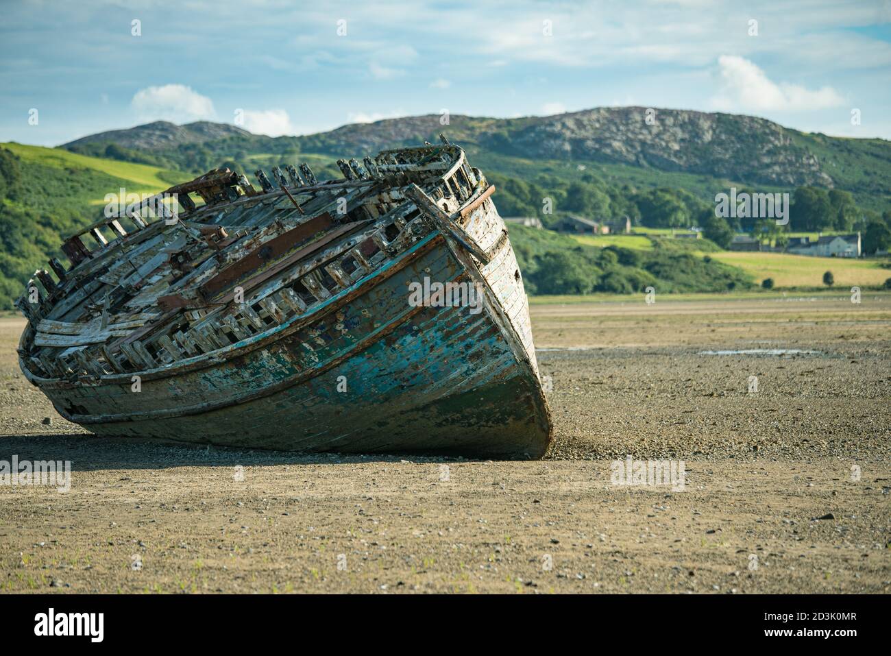 Barca di legno abbandonata che lentamente decadendo su Traeth Dulas, Anglesey, Galles Foto Stock