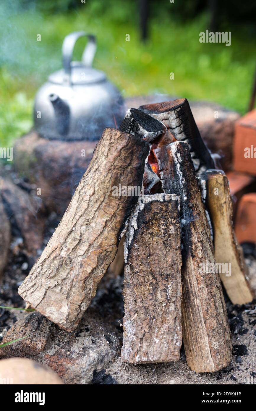bollitore per picnic all'aperto con un tocco vintage vicino a un falò. Cucina all'aperto, fuoco di cottura. Foto Stock