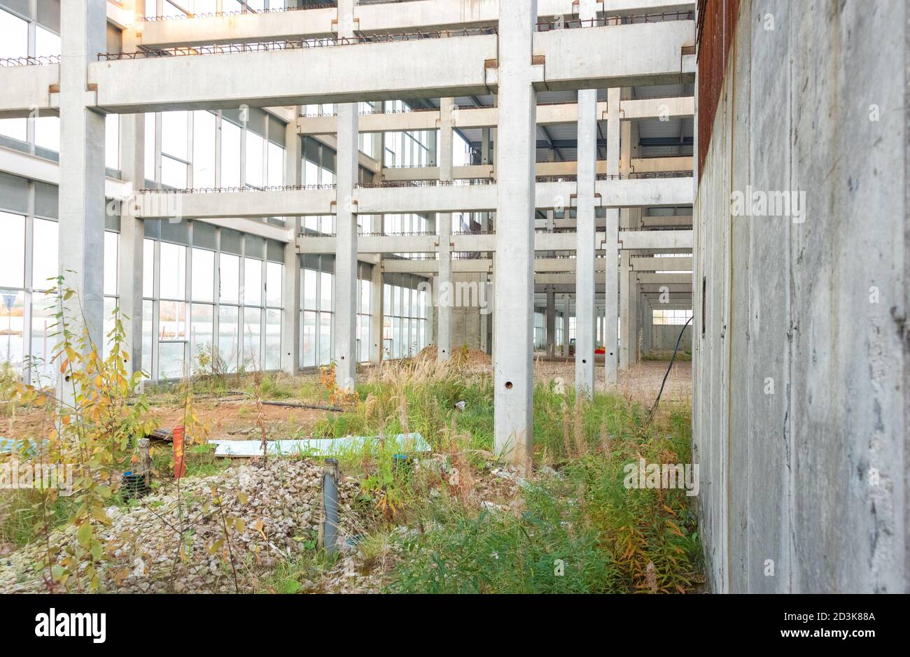 La costruzione di un centro commerciale è stata interrotta. Vista all'interno dell'edificio. Il cantiere è in crescita con erba. Foto Stock