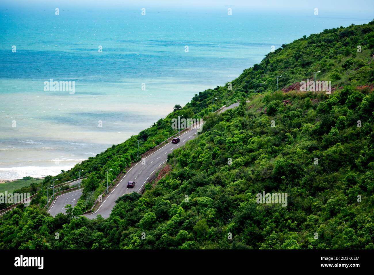 strada multistrato che va su una montagna che guarda impressionante con uno sfondo di spiaggia. Foto Stock