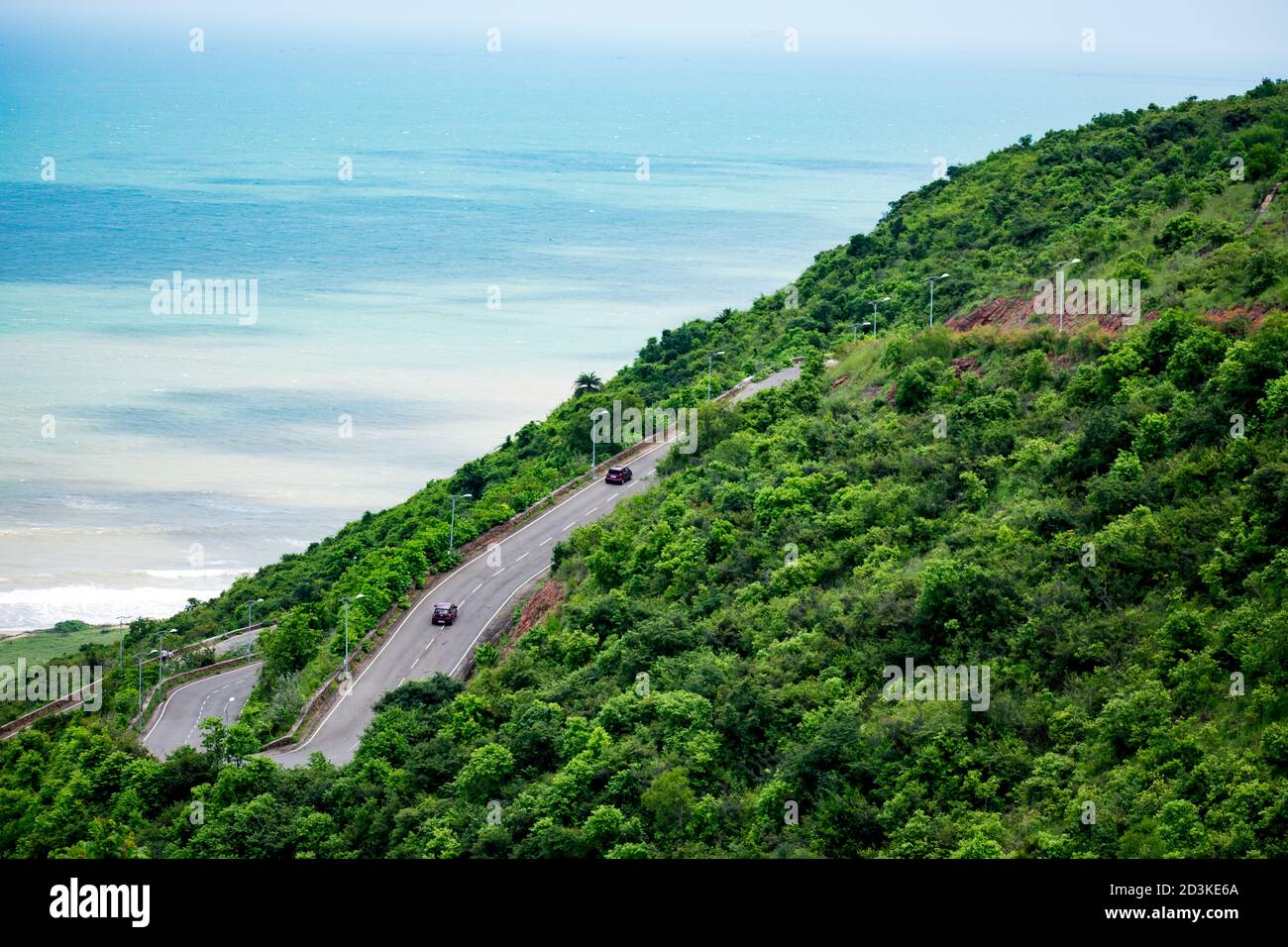 strada multistrato che va su una montagna che guarda impressionante con uno sfondo di spiaggia. Foto Stock