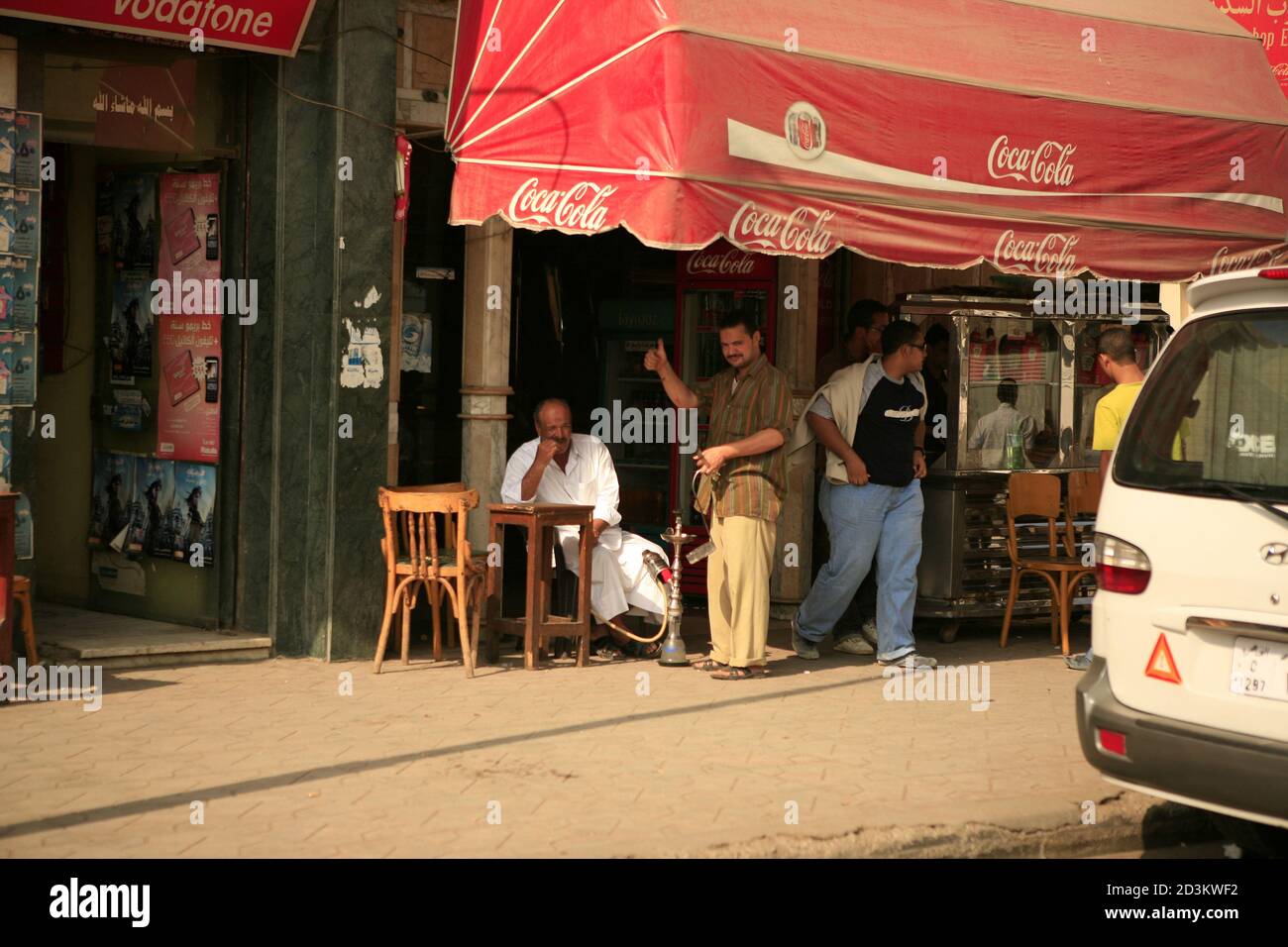 Vista sulla strada al Cairo. Un uomo sta fumando un hookah in un caffè di strada. Foto Stock