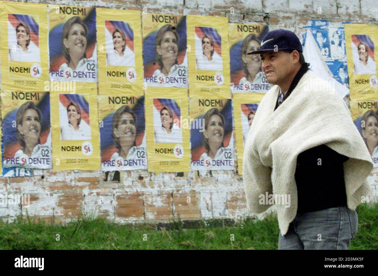 Un contadino colombiano cammina accanto a un muro con bandiere del candidato presidenziale colombiano Noemi Sanin a Guasca, vicino Bogotà, 21 maggio 2002. Le elezioni presidenziali colombiane si terranno il 26 maggio. REUTERS/Eliana Aponte EA/MMR Foto Stock