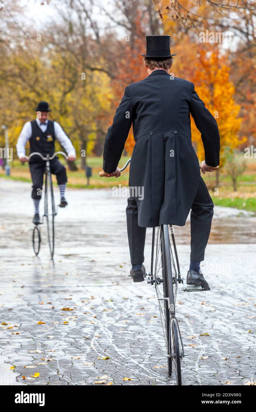 Due ciclisti sulla bicicletta Penny Farthing abbigliamento storico indossando la coda rivestimento Foto Stock