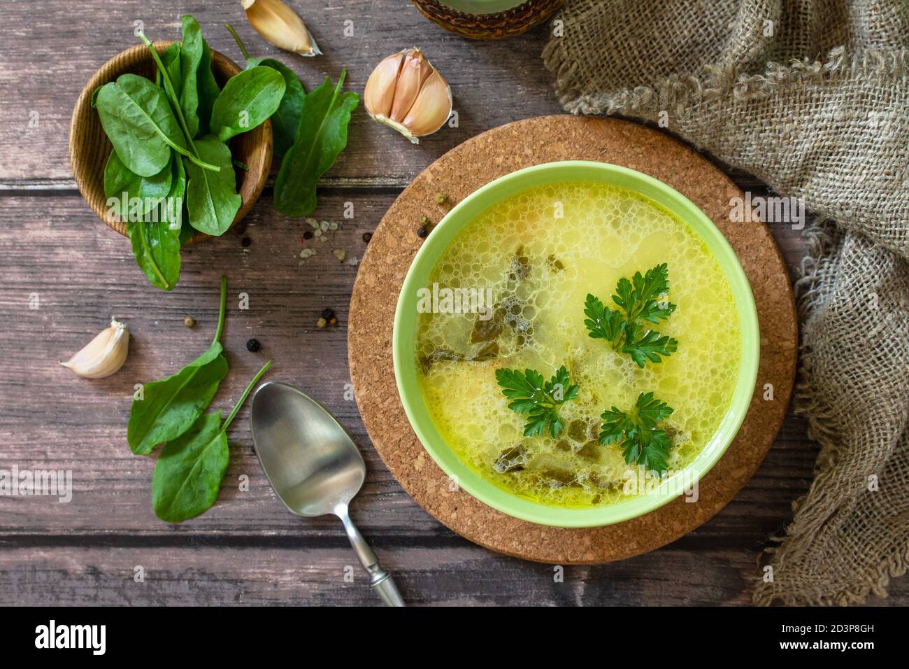 Zuppa di spinaci con panna su un rustico tavolo di legno. Vista dall'alto sfondo piatto. Foto Stock