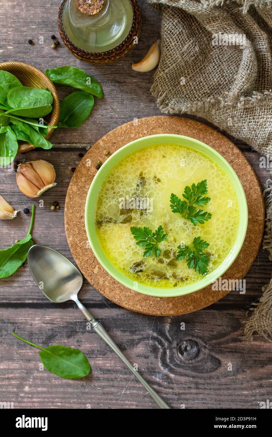 Zuppa di spinaci con panna su un rustico tavolo di legno. Vista dall'alto sfondo piatto. Foto Stock