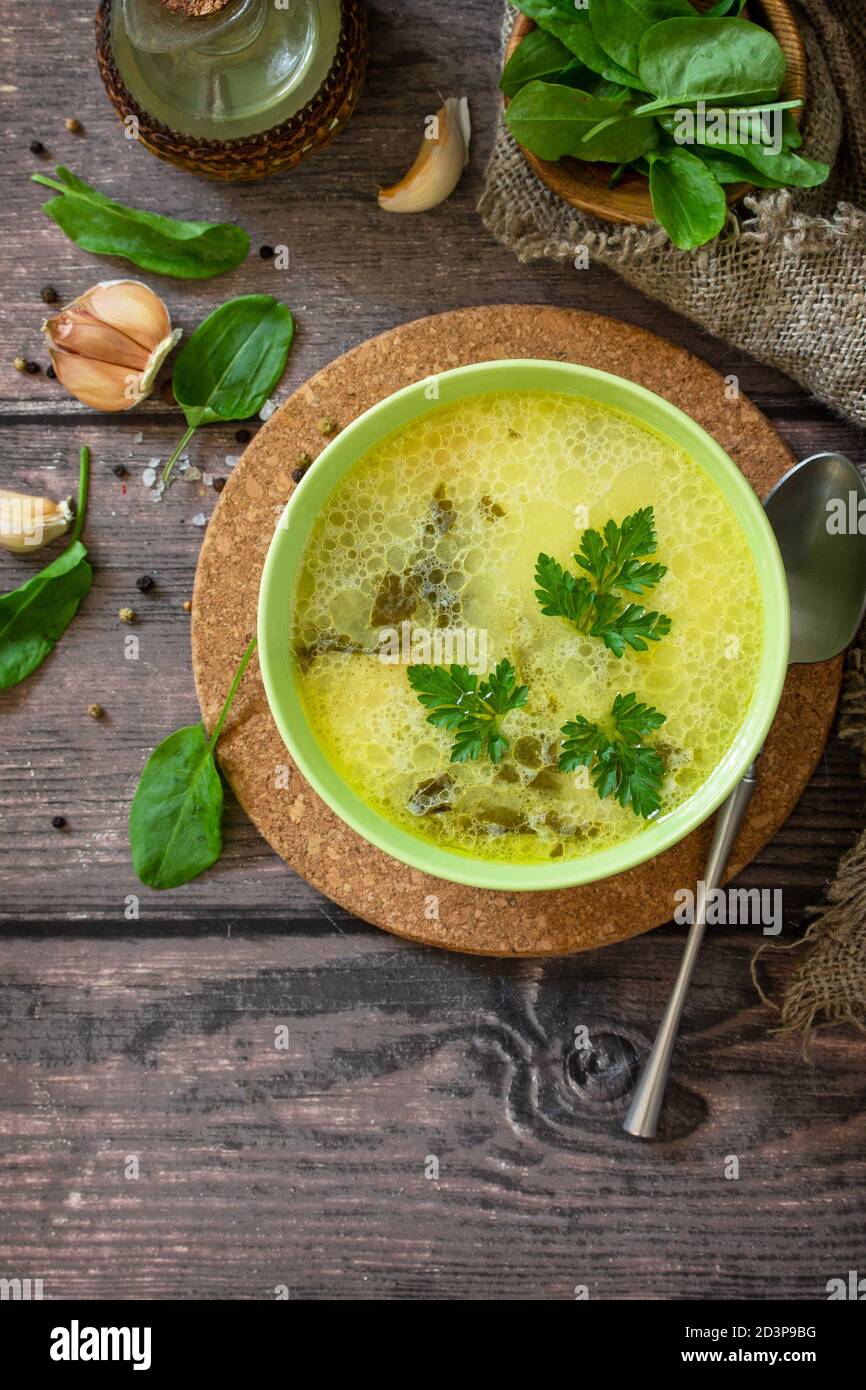 Zuppa di spinaci con panna su un rustico tavolo di legno. Vista dall'alto sfondo piatto. Spazio di copia. Foto Stock